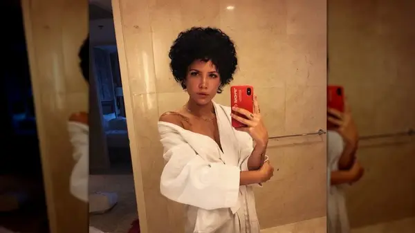 Halsey taking a mirror selfie with her curly, natural hair in a small afro