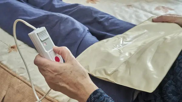 person using heating pad on abdomen
