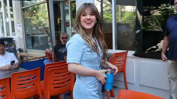 Kelly Clarkson pictured outside a New York City resturant with long hair and bangs