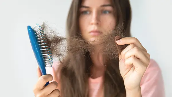 Woman cleaning hairbrush
