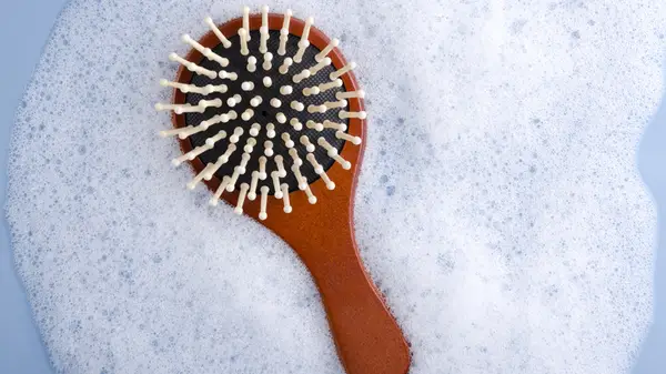 Woman removing hair from brush