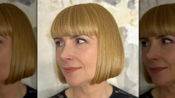 Woman with honey blonde blunt bob with heavy bangs