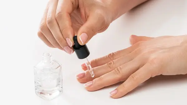Dropper with liquid on nail