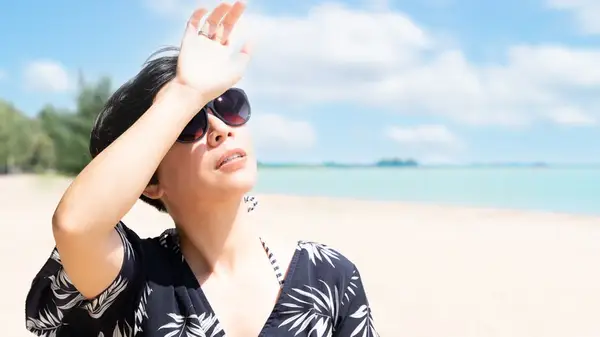 woman blocks sun with hands