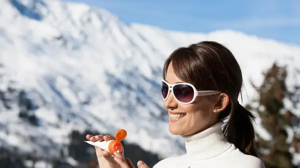 woman applying sunscreen outdoors