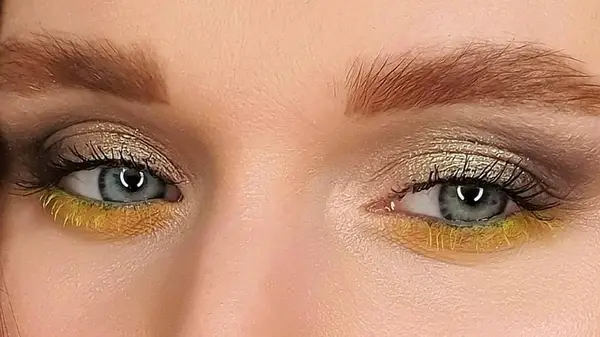 blue eyed woman wearing yellow mascara 