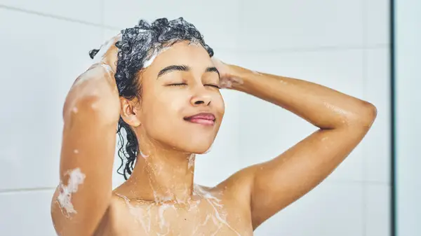 Woman smiling shampooing in shower
