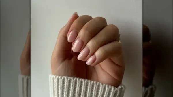 A hand with glossy pink nails