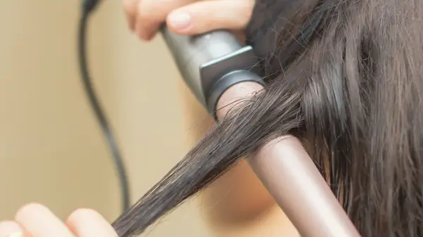 Woman holding a curling wand