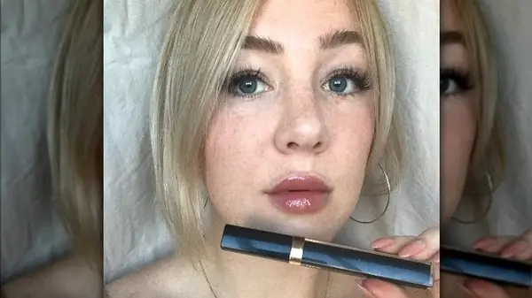woman holding black lipgloss tube