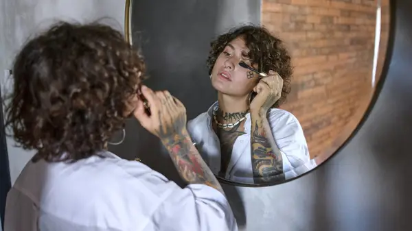 A woman applying mascara in the mirror