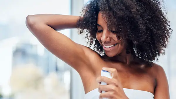 A woman applying deodorant