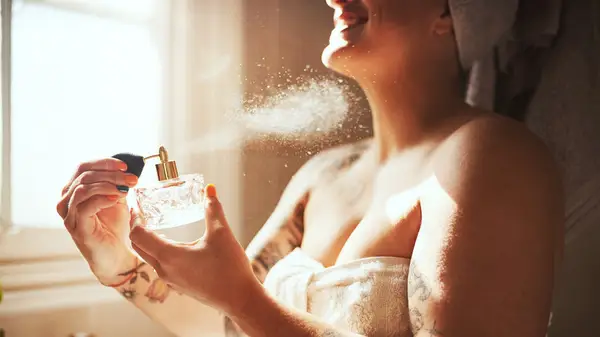 Woman applying perfume 