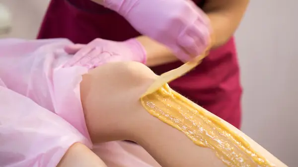 woman getting leg sugared