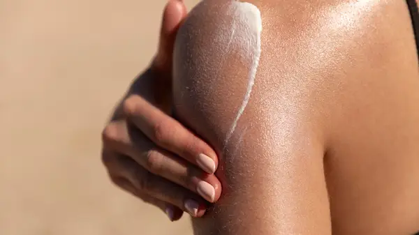 Woman putting on sunscreen 