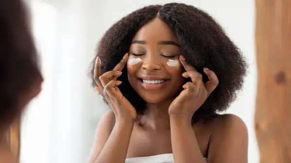 woman applying moisturizer