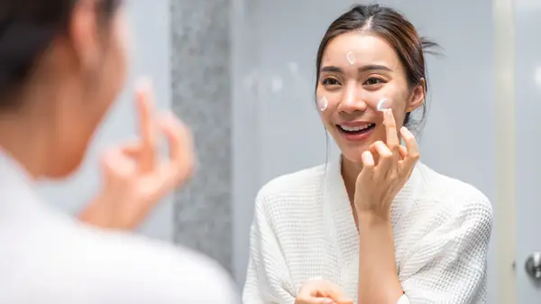 Woman applying moisturizer