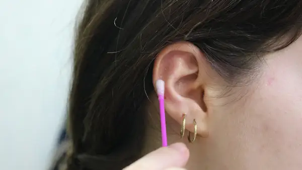 A woman cleaning her piercing