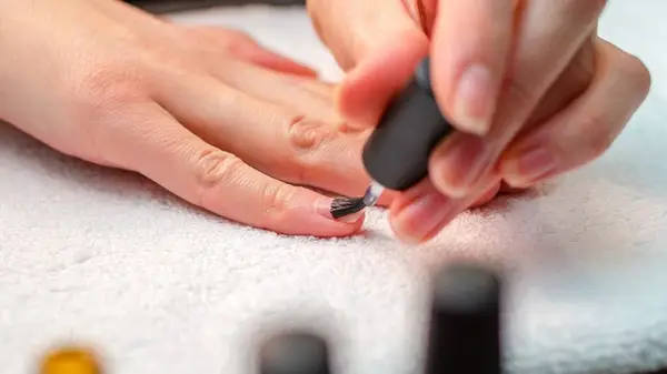 Woman applies nail primer