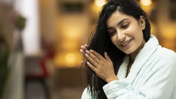 Woman applying oil to hair