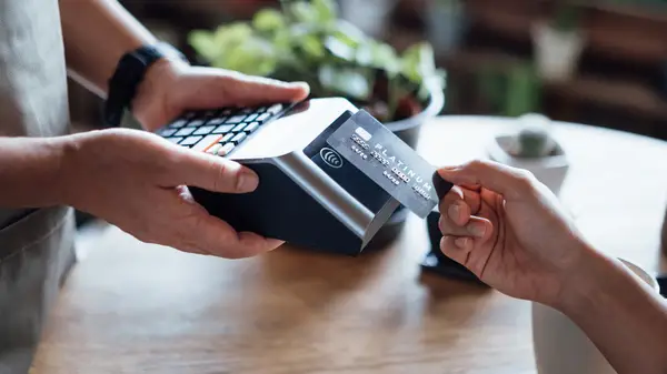 woman with nails holds credit card