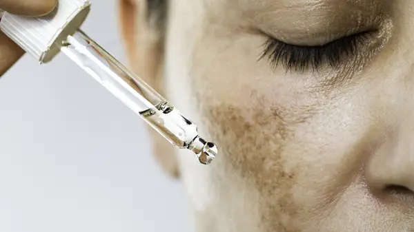 Person squeezing serum dropper