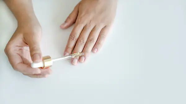 A woman applying cuticle oil