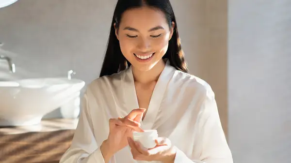 Smiling woman doing skincare routine