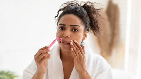 Woman shaving her face