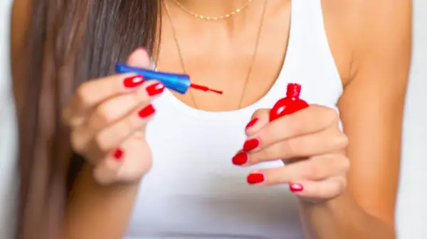 woman holding nail polish bottle