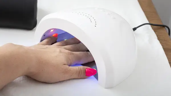 woman using gel polish machine