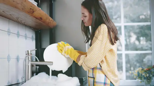 woman using gloves when washing dishes