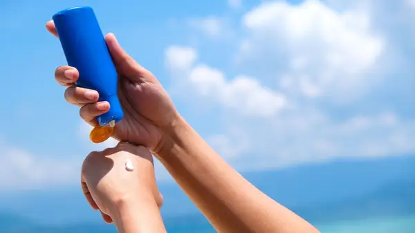 woman using sunscreen