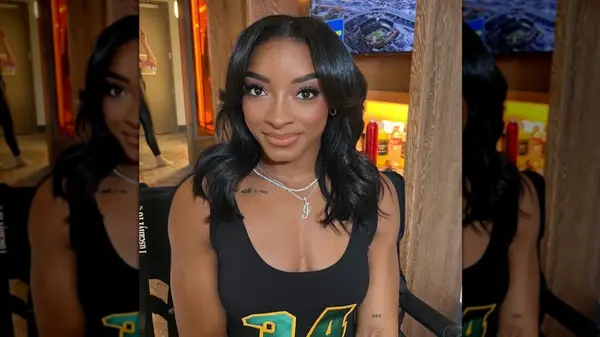 Simone Biles posing for a glam photo with two of her tattoos visible