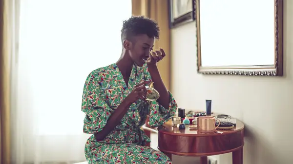 Woman smelling perfume on wrist