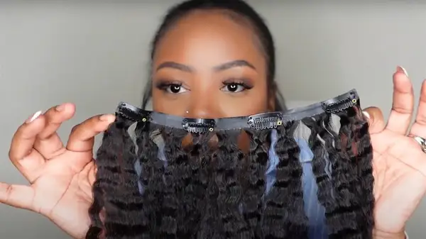 A woman holding up her clip-in extensions