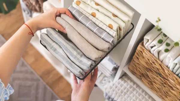 Woman reaching for clean pillowcases
