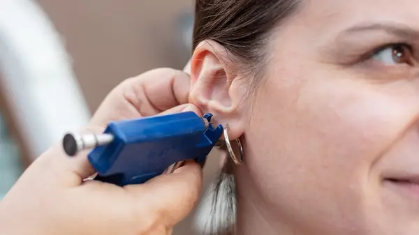 Piercing ear with piercing gun