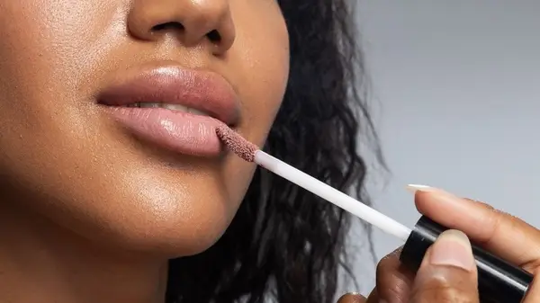 Woman applying lipgloss