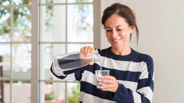 woman pouring glass of water