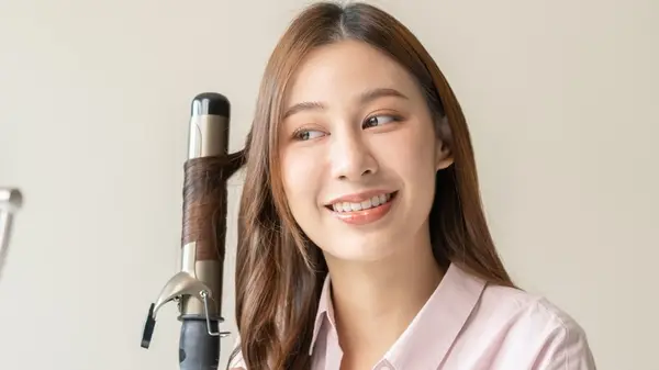 woman using hair styling tool 