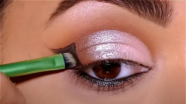 Woman drawing angel wing eyeliner