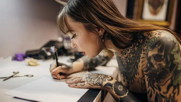 woman with tattoos drawing 