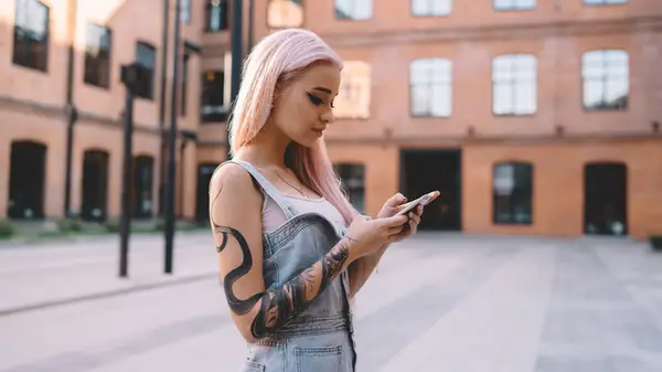 woman with tattoos texting