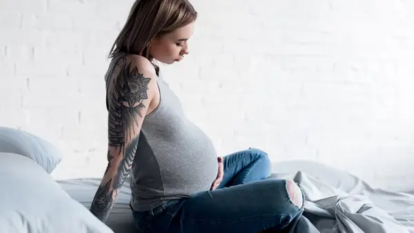 pregnant woman sitting on bed