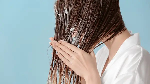 Woman applying mousse to hair