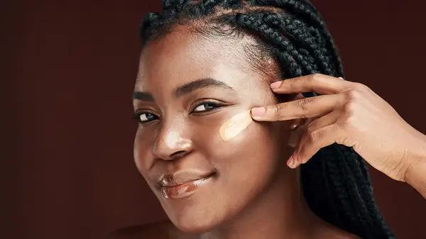 Woman applying foundation to face