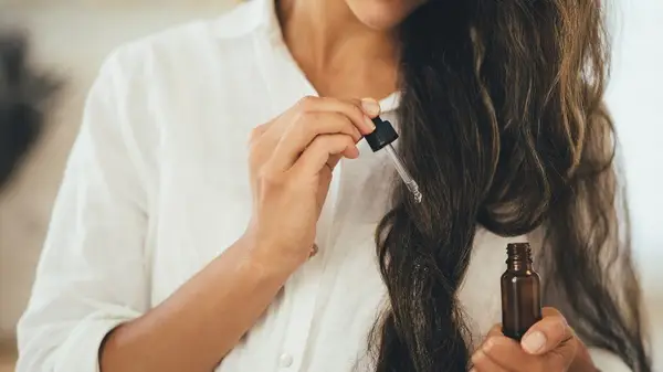 Woman applying hair oil