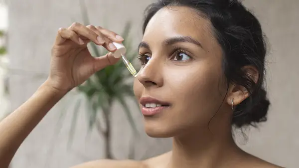 Woman applying oil serum
