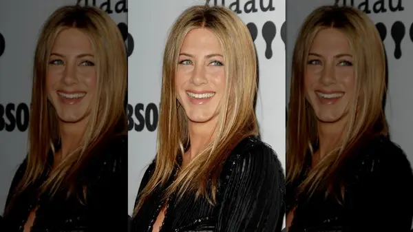Jennifer Aniston smiling with her straightened hair parted down the middle